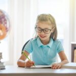 child is sitting at a desk indoors